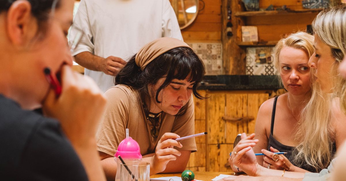 Estudiantes conversando alrededor de una mesa con cuadernos