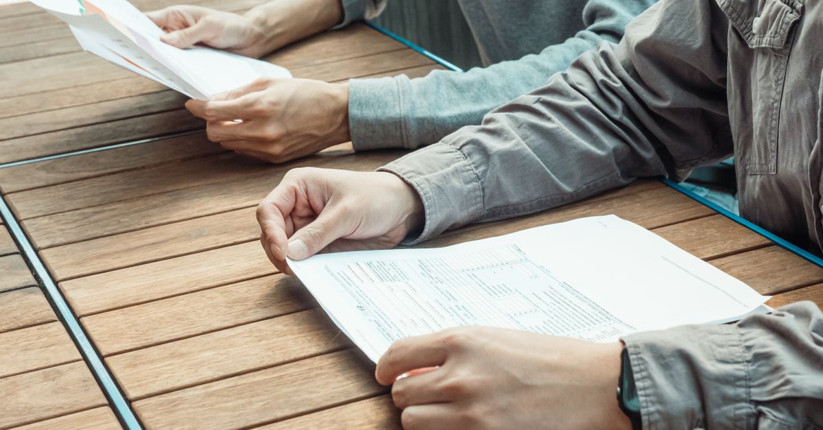 Persona joven revisando folletos informativos sobre una mesa