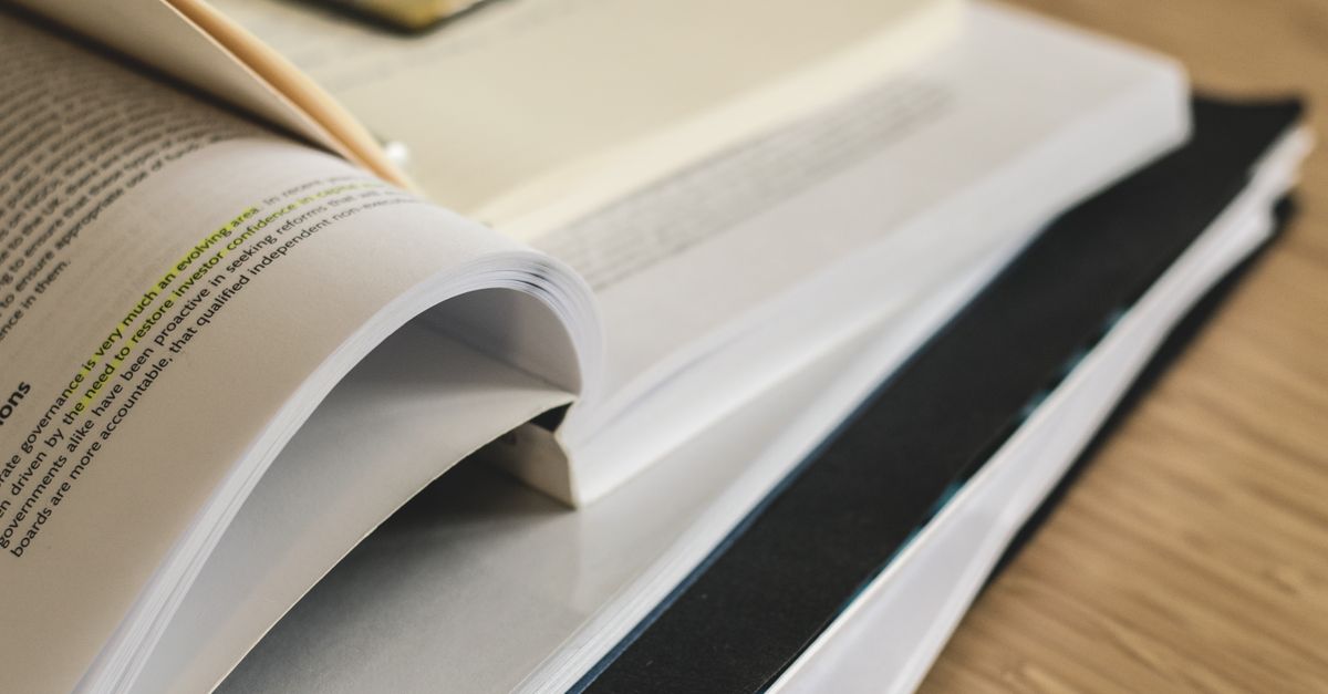 Documentos y libros abiertos sobre una mesa de estudio
